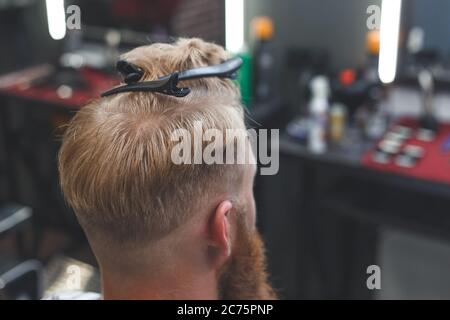 Services de coiffure. Processus de coiffage dans un salon de coiffure. Pince à cheveux avec une goupille en U lors de la coupe Banque D'Images