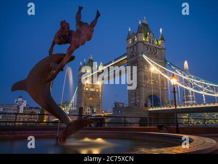 La première lumière du matin heure bleue commence à illuminer la célèbre jeune fille à la fontaine du Dauphin, le Tower Bridge et le fragment dans le centre de Londres. Banque D'Images