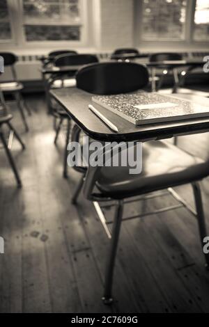 Un ordinateur portable et un crayon sur un bureau dans une vieille salle de classe Banque D'Images