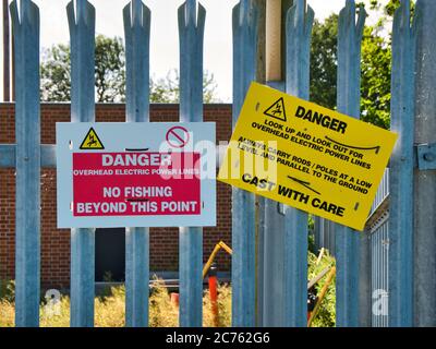 Panneaux d'avertissement sur le canal Leeds-Liverpool à Lancashire, Royaume-Uni - les panneaux interdisent la pêche en raison de la présence de lignes aériennes électriques Banque D'Images