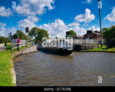 Un bateau à rames passe par le pont électrique tournant de New Lane sur Leeds jusqu'au canal de Liverpool près de Burscough dans Lancashire, Royaume-Uni. Banque D'Images