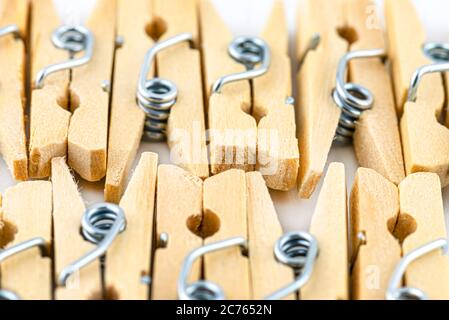 Macro-photographie de pinces miniatures en bois, situées sur un fond blanc, en deux rangées. Banque D'Images