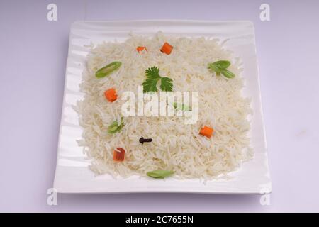 Légumes Pulav ou Pulao, fabriqués à partir de riz basmathi, légumes et épices indiennes. Disposés dans une vaisselle blanche carrée avec fond blanc ou textu Banque D'Images