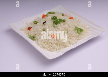 Légumes Pulav ou Pulao, fabriqués à partir de riz basmathi, légumes et épices indiennes. Disposés dans une vaisselle blanche carrée avec fond blanc ou textu Banque D'Images