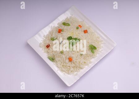 Légumes Pulav ou Pulao, fabriqués à partir de riz basmathi, légumes et épices indiennes. Disposés dans une vaisselle blanche carrée avec fond blanc ou textu Banque D'Images