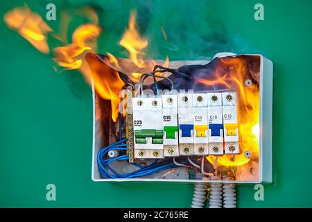 Un court-circuit a provoqué un incendie électrique. Des fils défectueux ont entraîné une surcharge du réseau électrique et de l'allumage. Le tableau de distribution dans la maison igni Banque D'Images