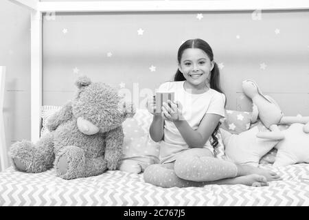 Lait chaud avant de dormir. Avantages pour la santé eau potable avant le lit. Mug pour petit enfant. Fille en pyjama buvant du thé. Détente avant sommeil. Boire du lait juste avant le lit. Boisson au coucher. Banque D'Images