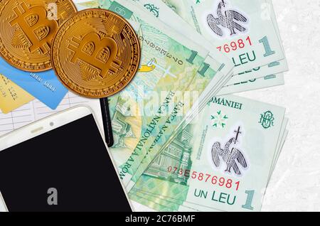 1 billets de leu roumain et bitcoins dorés avec smartphone et cartes de crédit. Concept d'investissement en crypto-monnaie. Opérations d'exploitation minière ou de commerce de crypto Banque D'Images