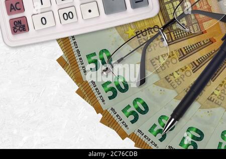 ventilateur de billets de 50 euros et calculatrice avec lunettes et stylo. Concept de saison de paiement de prêt d'entreprise ou d'impôt. Planification financière Banque D'Images