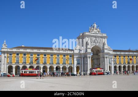 Place du Commerce (Praca do Comercio) et deux trams traditionnels rouges, à Lisbonne, Portugal Banque D'Images