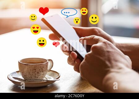 Gros plan des mains de l'homme tenant le smartphone mobile avec écran vide de l'espace de copie. Image d'un homme assis à une table avec un café dans un café et utilisant mobil Banque D'Images