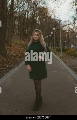 Une belle fille marche le long de l'allée dans le parc d'automne. Banque D'Images