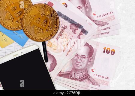 100 billets de banque thaïlandais et bitcoins dorés avec smartphone et cartes de crédit. Concept d'investissement en crypto-monnaie. Opérations d'exploitation minière ou de commerce de crypto Banque D'Images