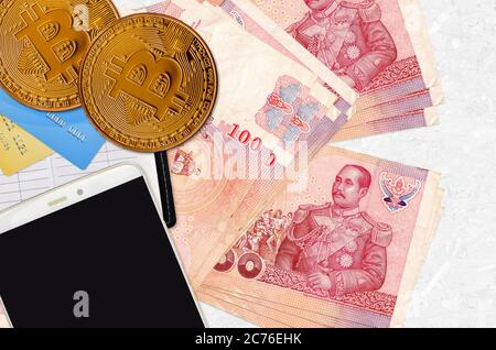 100 billets de banque thaïlandais et bitcoins dorés avec smartphone et cartes de crédit. Concept d'investissement en crypto-monnaie. Opérations d'exploitation minière ou de commerce de crypto Banque D'Images