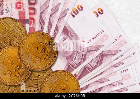 100 billets de baht thaïlandais et bitcoins dorés. Concept d'investissement en crypto-monnaie. Opérations d'exploitation minière ou de commerce de crypto Banque D'Images