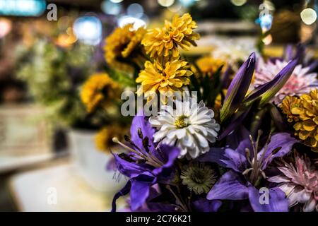 Décoration de différentes fleurs artificielles. Gros plan de l'installation de fleurs inanimées. Banque D'Images