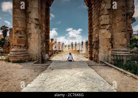 Bonne femme appréciant la beauté et la majesté des colonnes hautes et des Arches des ruines de Tyr. Excursion dans la nécropole. Liban. Découvrir le monde. Banque D'Images