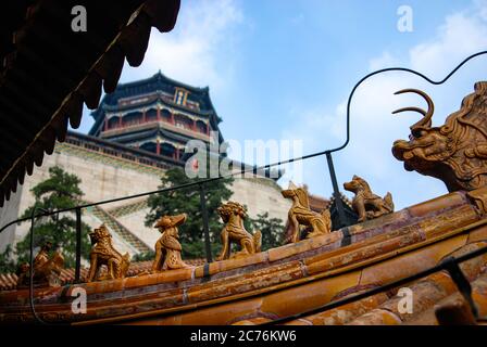 Une vue sur les sculptures de la crête chinoise utilisées sur les toits des bâtiments dans l'architecture chinoise avec le Palais d'été Banque D'Images