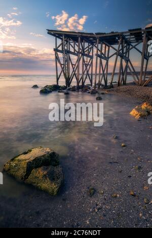 Belle vue d'une mer à côté d'un ponton tourné au lever ou au coucher du soleil par la mer Noire à Tuzla, Conty Constanta Roumanie Banque D'Images