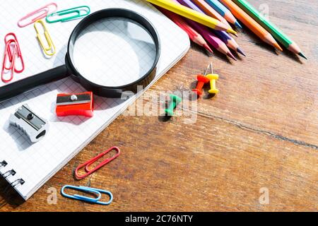 Retour à l'école: Livre de notes, crayons, loupe, pomme verte sur table en bois Banque D'Images