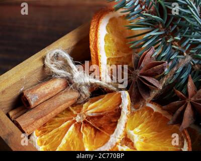 Composition des fêtes de Noël : belles branches d'épicéa , d'oranges sèches, de bâtons de cannelle et d'anis étoilé dans une boîte en bois. Banque D'Images
