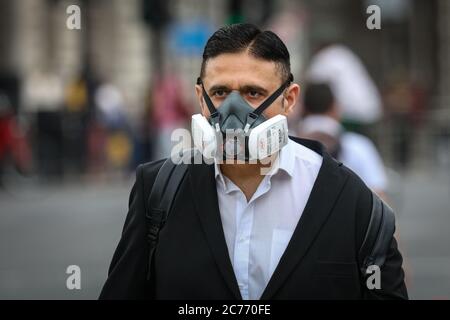 Westminster, Londres, Royaume-Uni. 14 juillet 2020. Un homme ne prend aucun risque en portant un masque filtrant à Westminster. Masques de visage déjà obligatoire dans les transports publics, et un également requis dans les magasins et les supermarchés à partir du 24 juillet en Angleterre. Crédit : Imagetraceur/Alamy Live News Banque D'Images