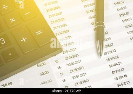 Gros plan du stylo et de la calculatrice sur les documents financiers. Tableau statistique avec des nombres sur le tableau. Finances et rapport de l'entreprise avec les bénéfices et l'investissement Banque D'Images