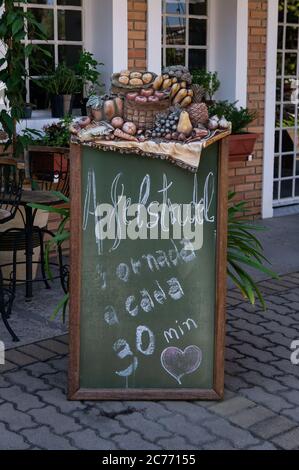 Un tableau noir devant une boulangerie montrant quand des lots nouveaux et frais d'Apfelstrudel (strudel de pomme - strudel traditionnel viennois) sont disponibles Banque D'Images