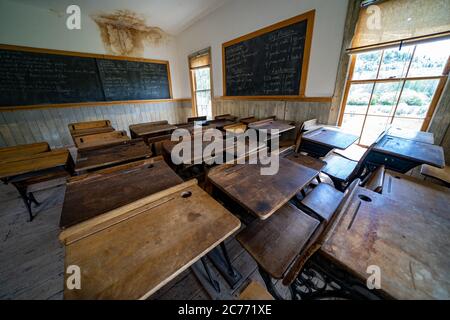 Bannack, Montana - 29 juin 2020 : à l'intérieur de l'ancienne école restaurée, avec des bureaux et un tableau noir dans la ville fantôme au parc national Banque D'Images