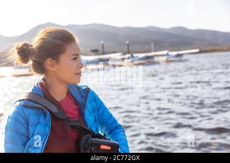 Femme touristique sur l'aventure voyage en plein air vacances en Alaska. Photographe asiatique de fille en croisière avec des avions de float en arrière-plan Banque D'Images