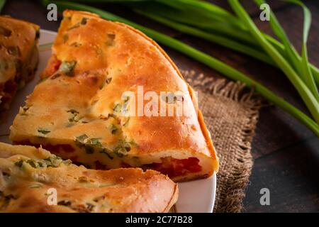 Délicieuse tarte maison avec poulet, herbes et tomates sur une assiette. Banque D'Images