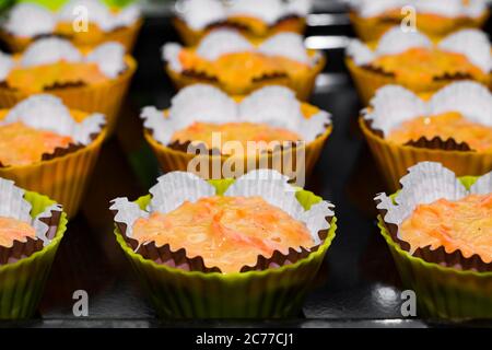 Pâte pour muffins dans des moules en papier. Le processus de fabrication de gâteaux de raisins secs faits maison. Mise au point sélective, vue de dessus. Banque D'Images