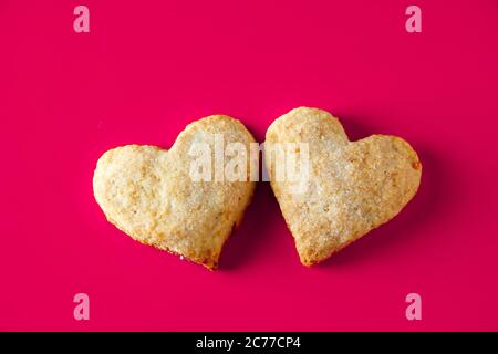 Biscuits en forme de coeur pour la Saint Valentin sur fond rose. Deux biscuits en forme de cœur sur fond rose. Symbole de Saint Valentin et d'amour. Banque D'Images