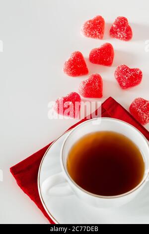 Tasse de thé sur fond blanc et marmelade rouge en forme de coeur. Le concept de fumée d'une tasse sous forme de coeur, symbole des amoureux Banque D'Images