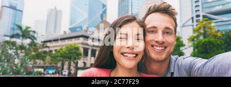 Bannière panoramique pour les jeunes souriants, portrait selfie. Deux couples de touristes voyageant à Hong Kong, prenant des photos avec le téléphone en vacances d'été. Asie Banque D'Images