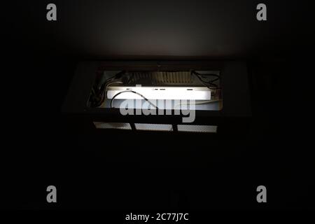 Gros plan et foyer sélectif de la lampe fluorescente à l'intérieur de la boîte de sortie exposée fixée au plafond, vue arrière Banque D'Images