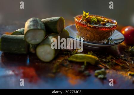 Gros plan sur une plaque de verre de la célèbre Galka nu Shaak du Gujarati. Prise de plat de gourde éponge dans une assiette de verre avec toutes les épices sur un brun avec Banque D'Images