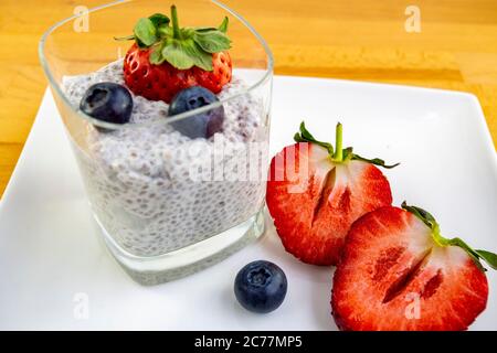 Un pudding de chia sain dans un verre avec du lait d'amande et des baies fraîches Banque D'Images