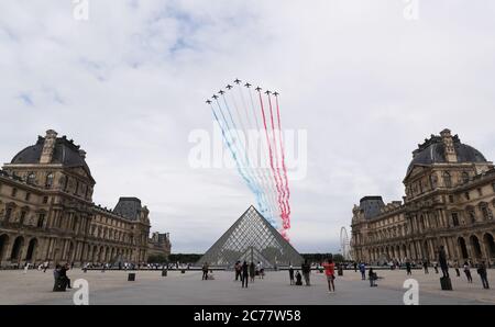 (200715) -- QINGDAO, 15 juillet 2020 (Xinhua) -- la Patrouille de France, Force aérienne française, survole la pyramide du Musée du Louvre lors de la fête de la Bastille à la place de la Concorde à Paris, France, le 14 juillet 2020. Sans le défilé militaire traditionnel sur la célèbre avenue des champs-Elysées et la célébration publique, le président français Emmanuel Macron a présidé mardi la cérémonie du 14 juillet éclipsée par la crise du coronavirus. Pour la célébration de cette année, le défilé militaire, qui a traditionnellement attiré d'énormes foules, a été annulé pour la première fois depuis 1945 an Banque D'Images