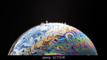 gros plan d'une bulle de savon colorée isolée sur un fond noir, qui ressemble à une planète dans l'espace. Banque D'Images