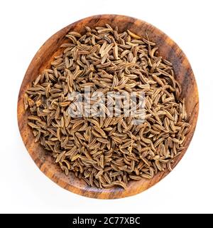 Graines de caraway dans bol en bois vue de dessus isolée sur blanc. Banque D'Images