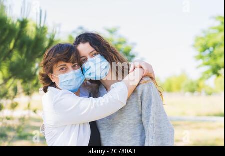 Distance sociale. Mère et fille avec un masque de protection qui se serre dans un parc. Mettre fin à la pandémie du coronavirus. Coronavirus. Distanciation sociale Banque D'Images