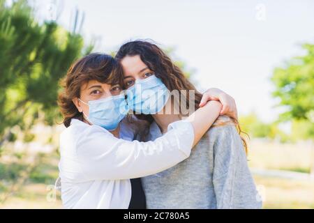 Distance sociale. Mère et fille avec un masque de protection qui se serre dans un parc. Mettre fin à la pandémie du coronavirus. Coronavirus. Distanciation sociale Banque D'Images