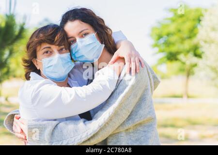 Distance sociale. Mère et fille avec un masque de protection qui se serre dans un parc. Mettre fin à la pandémie du coronavirus. Coronavirus. Distanciation sociale Banque D'Images