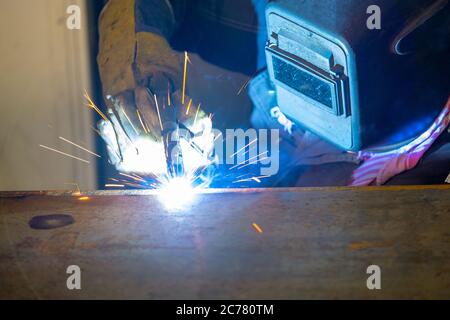 Soudeur, travaillant avec le soudage à l'arc semi-automatique dans l'atelier de production. Banque D'Images