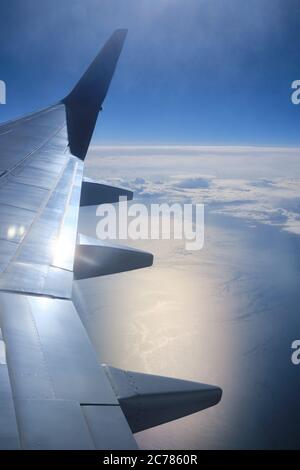 Aile d'avion au-dessus de l'océan vue verticale. Ciel vertical et vue sur la mer depuis le hublot Banque D'Images