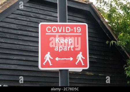 Un panneau d'avertissement de Covid-19 et d'instruire les gens de garder leur distance. Banque D'Images