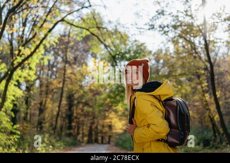 Femme touriste avec sac à dos dans la forêt d'automne. Mode de vie actif, concept de voyage Banque D'Images