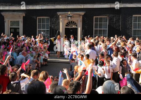 La flamme olympique rejoint le Premier ministre David et Samantha Cameron au numéro 10 Downing Street, porté par Ceri Davies qui a transmis la flamme à Florence Rowe. 25 juillet 2012 --- image de © Paul Cunningham Banque D'Images