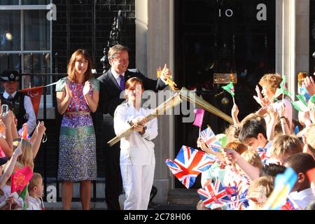 Le relais de la flamme olympique rejoint le Premier ministre David et Samantha Cameron au numéro 10 Downing Street, porté par Ceri Davies qui a transmis la flamme à Florence Rowe.25 juillet 2012 --- image de © Paul Cunningham Banque D'Images